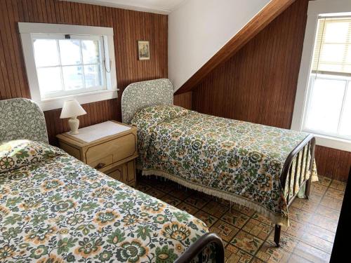 a room with two beds and a table and two windows at Cozy Cottage by the Sea in York