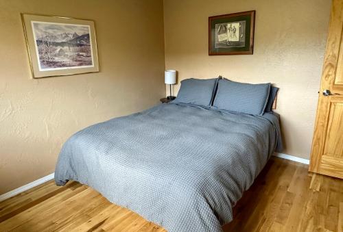 a bedroom with a bed with blue pillows at Lakeviewlanding in Big Arm