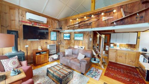 a living room with a couch and a tv at Pond View Cabin in Chittenden