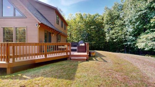 a house with a deck with a chair on it at Beechwood Home in Mendon