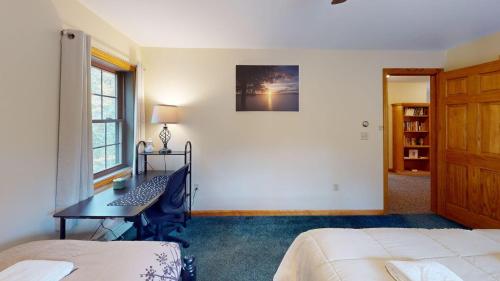 a bedroom with a bed and a desk and a window at Beechwood Home in Mendon