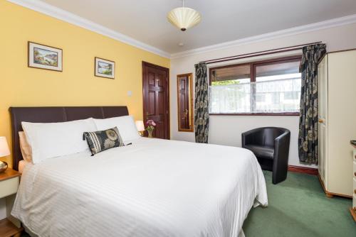 a bedroom with a white bed and a window at B&B Meadow View in Penrith