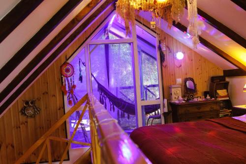 a bedroom with a bed and a window with purple lighting at budabu in Sighnaghi