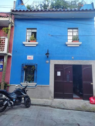 a motorcycle parked in front of a blue building at Habitación en casa familiar in Antigua Guatemala