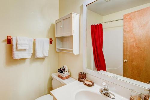 baño con lavabo blanco y cortina de ducha roja en Banner Bunks at River Run, en Banner Elk