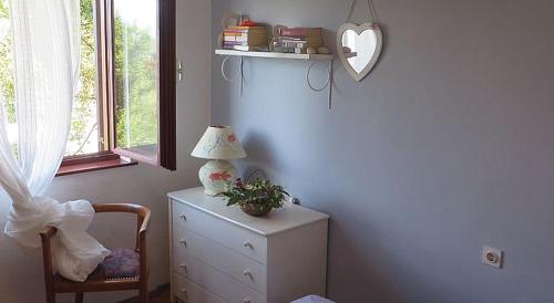 a bedroom with a dresser and a lamp and a chair at Holiday Home Bukovac in Klimno