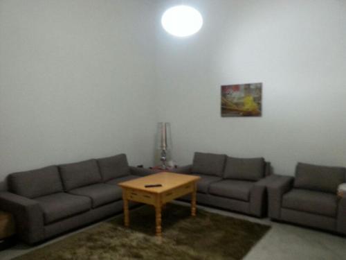 ein Wohnzimmer mit 2 Sofas und einem Couchtisch in der Unterkunft Appartement en plein centre ville in Fès