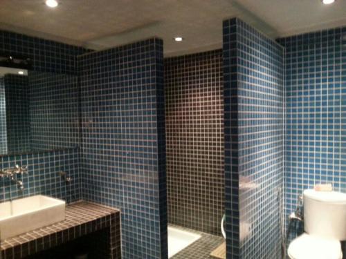 a blue tiled bathroom with a toilet and a sink at Appartement en plein centre ville in Fez