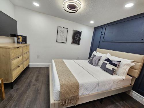 a bedroom with a large bed and a dresser at The Hideaway DT Orlando Tiny Home w Free Parking in Orlando