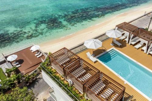 an overhead view of a swimming pool and the beach at The Sands #1 - New 7Mile Beach Condo with Rooftop Pool & Luxe Interiors in West Bay