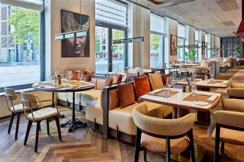 a restaurant with tables and chairs and windows at Berlin Marriott Hotel in Berlin