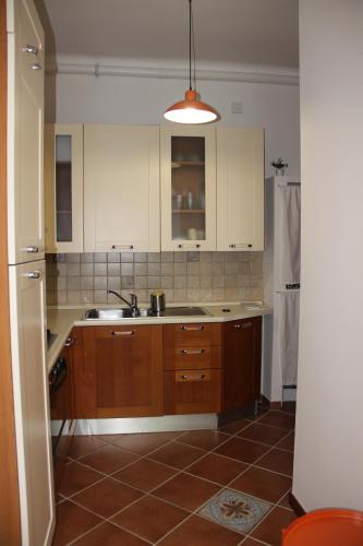 a kitchen with wooden cabinets and a sink at Pretty Favetti - lovely apartment in Trieste with a sea view - in Trieste
