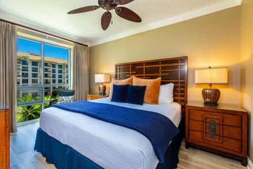 una camera da letto con un letto grande e un ventilatore a soffitto di Honua Kai Hokulani 310 by Coldwell Banker Island Vacations a Kaanapali