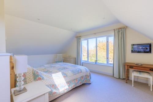 ein Schlafzimmer mit einem Bett und einem großen Fenster in der Unterkunft Lower Marsh Cottage in Brightlingsea