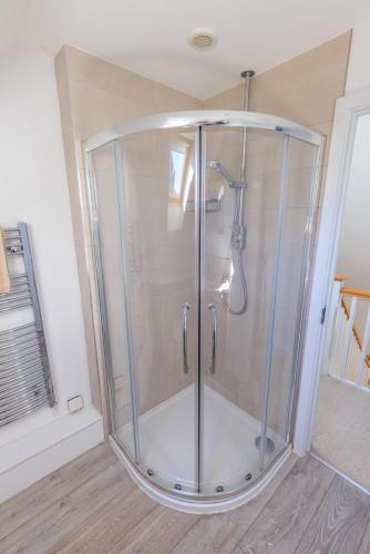 a shower with a glass enclosure in a room at Lower Marsh Cottage in Brightlingsea