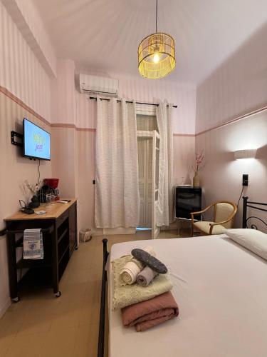 a bedroom with a bed and a desk and a television at Classic rooms in the center in Loutraki