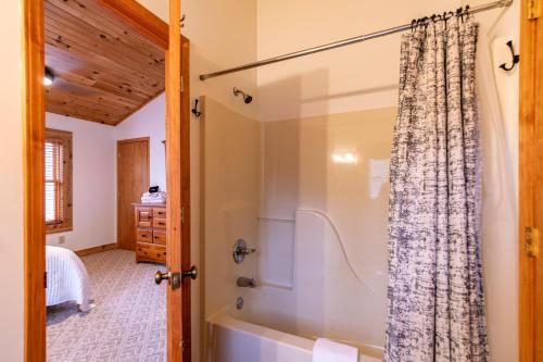a bathroom with a tub and a shower at Happy Trees Cabin in Laxon