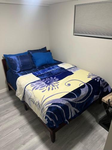 una camera da letto con un letto con coperte e cuscini bianchi e blu di Winnipeg Bright Home a Winnipeg