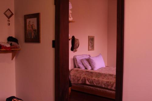 a bedroom with a bed with pink walls and a mirror at La pequeña casa in Pijao