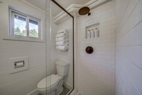 a white bathroom with a toilet and a shower at Beach Access, Deck Waterfront Whidbey Island Home in Greenbank