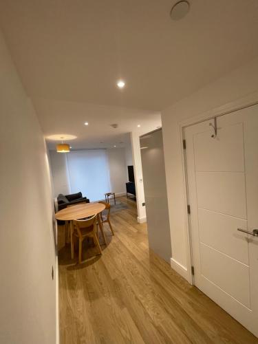 a living room with a table and a door at Cozy one bed with Large Balcony In Birmingham city center in Birmingham