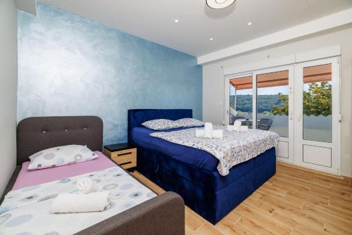 a bedroom with two beds and a window at Apartments Ankica in Kampor