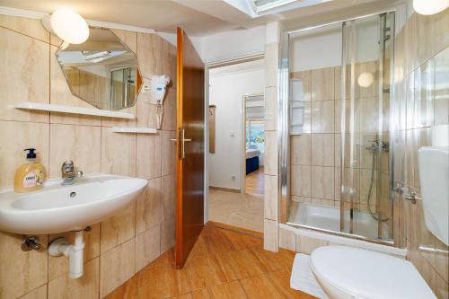 a bathroom with a sink and a shower and a toilet at Apartments Ankica in Kampor