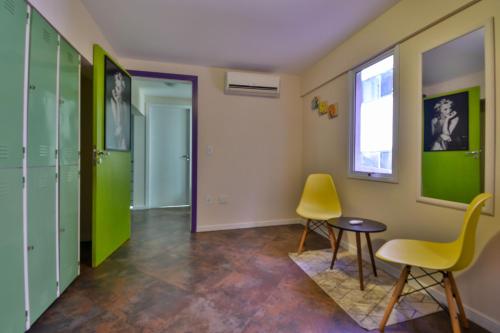 a room with green lockers and a table and chairs at Hostel Toca da Moréia Bombinhas in Bombinhas