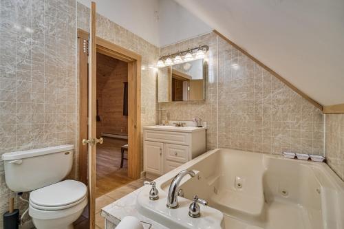 a bathroom with a tub and a toilet and a sink at Mountain-View Deck! Cabin By Mt Abraham Trails in Kingfield