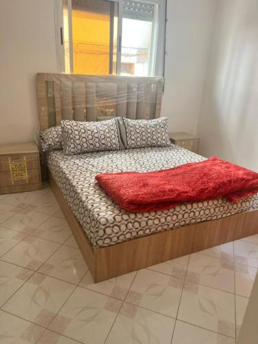 a bed in a room with a red blanket on it at Casa youssef 2 in Asilah
