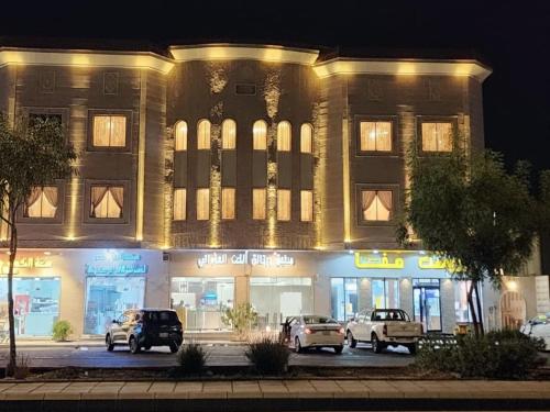 a building with cars parked in front of it at night at النبلاء in Al Madinah