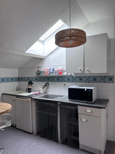 una cucina con lavello e microonde di O'Sweet Home I Wifi I Parking I Près de la gare a Orléans