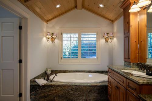 a bathroom with a large tub and a window at Hinesight at Hound Ears in Valle Crucis
