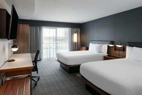 a hotel room with two beds and a desk at Courtyard Richland Columbia Point in Richland