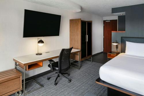 a hotel room with a bed and a desk with a computer at Courtyard Richland Columbia Point in Richland