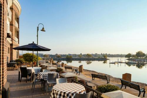 a patio with tables and chairs next to a body of water at Courtyard Richland Columbia Point in Richland