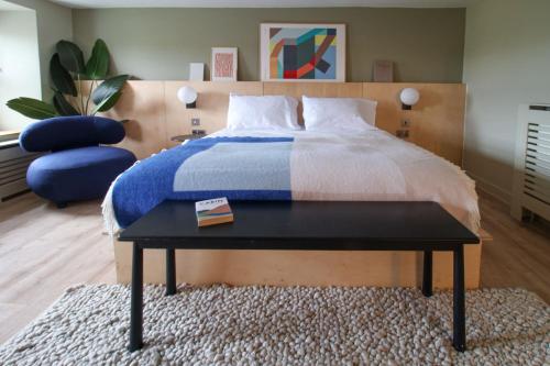 - une chambre avec un lit, une chaise bleue et une table dans l'établissement Luxury 4-Bed Farmhouse Retreat in Yorkshire Dales, à Gaisgill