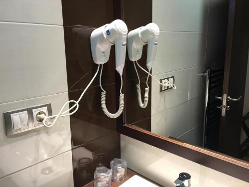 un baño con dos teléfonos colgando de una pared en Hotel Calzada en Arcos