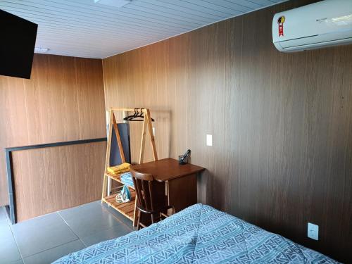 a bedroom with a bed and a wooden wall at Sobrado de Container Azul in Dourados