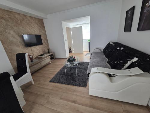 a living room with a couch and a tv at Relax apartman 01 in Leskovac