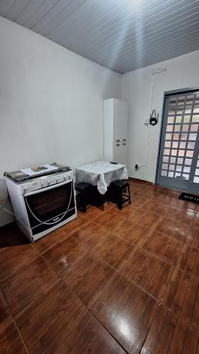 a living room with a stove and a wooden floor at casa kitnet in Maracaju