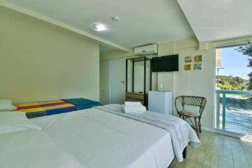 a bedroom with two beds and a chair and a window at Hostel Toca da Moréia Bombinhas in Bombinhas