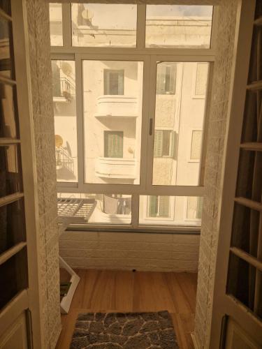 - une fenêtre dans une chambre avec vue sur un bâtiment dans l'établissement Appartement spacieux au centre-ville, à Tetouan