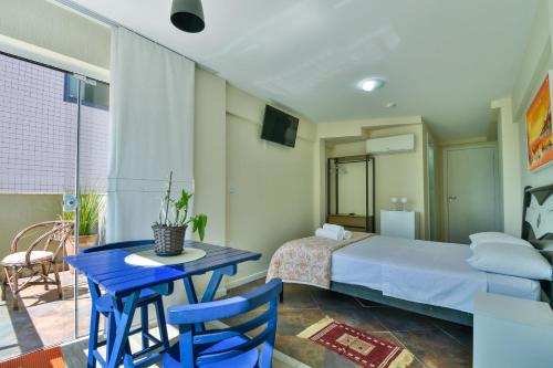 a bedroom with a bed and a table and chairs at Hostel Toca da Moréia Bombinhas in Bombinhas