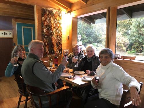 a group of people sitting around a table drinking wine at Posada de Expediciones Kahuel in Chaitén