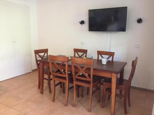 a dining room table with chairs and a television on a wall at Appartement T3 à Uhart-Cize in Uhart-Cize