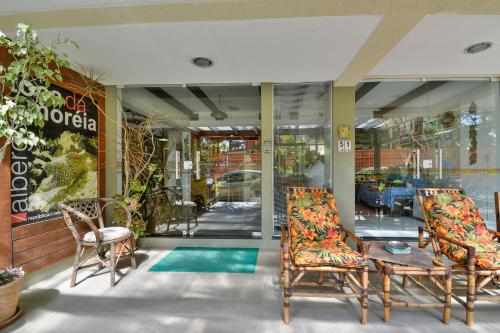 a store front with two chairs and a table at Hostel Toca da Moréia Bombinhas in Bombinhas