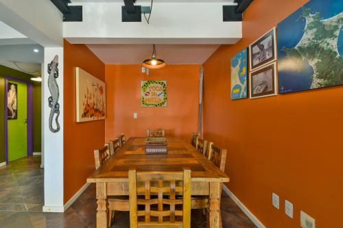 a dining room with a wooden table and chairs at Hostel Toca da Moréia Bombinhas in Bombinhas