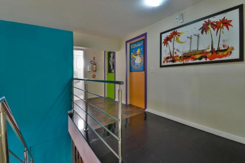 a hallway with a staircase and a painting on the wall at Hostel Toca da Moréia Bombinhas in Bombinhas