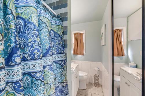a bathroom with a shower with a blue and white shower curtain at Barefoot Bungalow SPV26 in Port Aransas